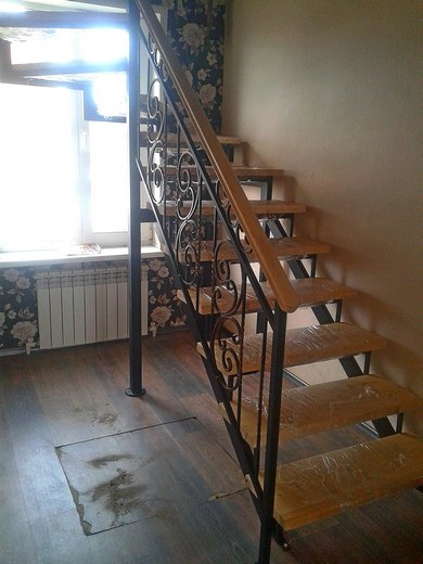Лестница на металлокаркасе с забежными ступенями и поворотом на 180, с деревянными ступенями и кованым ограждением с патиной Углич